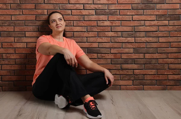 Overweight Woman Sitting Brick Wall Indoors Space Text — 스톡 사진