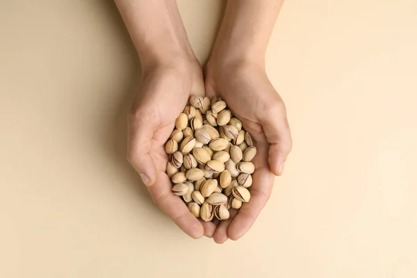Woman Holding Tasty Roasted Pistachio Nuts Beige Background Top View —  Fotos de Stock