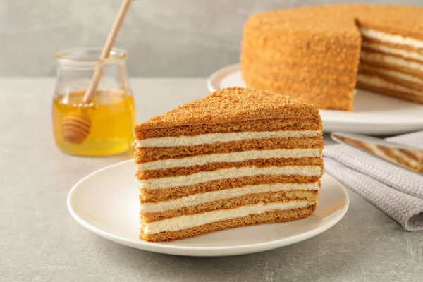 Skiva Läckra Lager Honung Kaka Serveras Grått Bord Närbild — Stockfoto