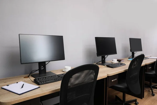 Offene Büroräume Moderne Arbeitsplätze Mit Computern Nahe Hellgrauer Wand — Stockfoto