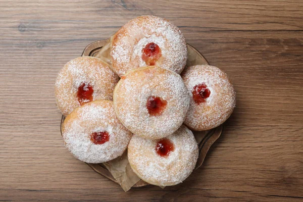 Ahşap masanın üstünde reçelli ve pudra şekerli leziz çörekler.