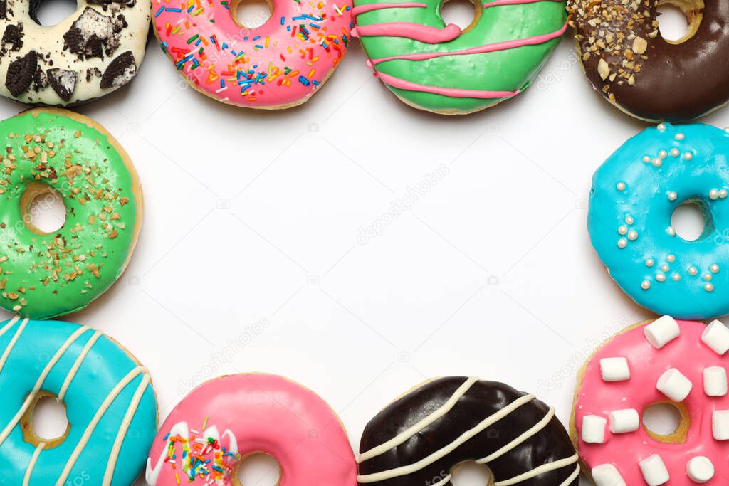 Different delicious glazed doughnuts on white background, top view. Space for text