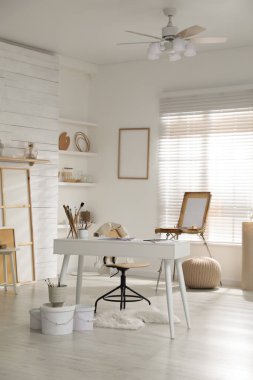 Sanatçının iş yeri ve sanat malzemeleriyle modern stüdyo içi