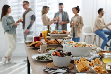 Brunch table setting with different delicious food	and blurred view of people on background