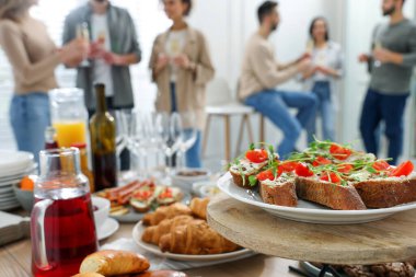 Brunch table setting with different delicious food	and blurred view of people on background