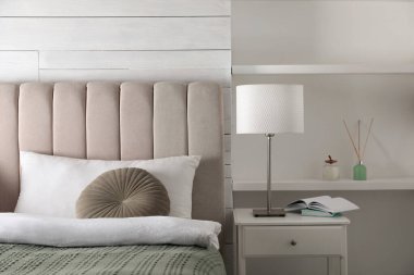 Yatak odasındaki komodinin üzerinde şık bir gece lambası.