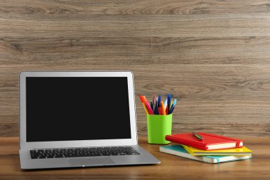 Modern laptop ve ofis malzemeleri ahşap masada. Uzaklık öğrenimi