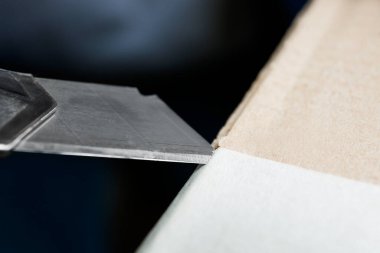 Paketi açmak için bıçak kullanılıyor, yakın plan.