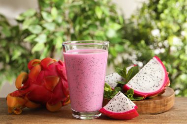 Nefis pitahaya smoothie ve ahşap masada taze meyveler.