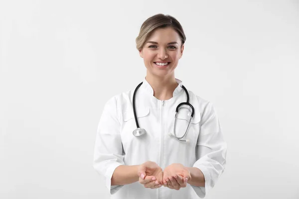 Doutor Com Estetoscópio Segurando Algo Fundo Branco Conceito Cardiologia — Fotografia de Stock