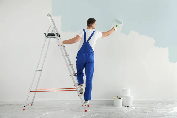 Hombre Pintura Pared Con Tinte Azul Claro Interior Vista Trasera — Foto de Stock