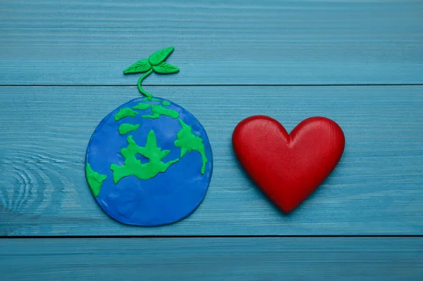 地球日快乐 绿松石木桌上的塑料行星和装饰心 — 图库照片