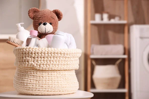 用婴儿用品 浴具和玩具熊编织的篮子放在室内的白桌上 案文的篇幅 — 图库照片