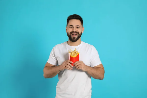 Jeune Homme Avec Des Frites Sur Fond Bleu Clair — Photo