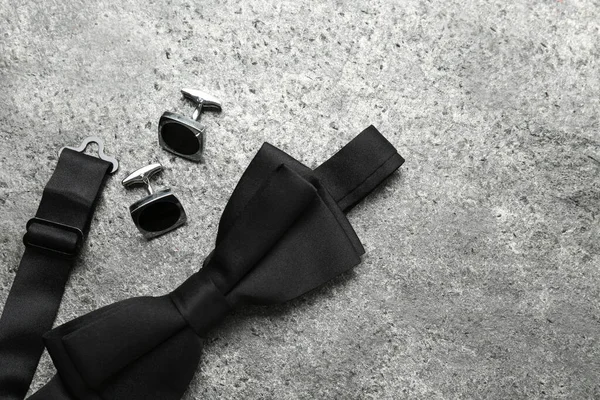 Stylish Black Bow Tie Cufflinks Grey Stone Background Flat Lay — Stockfoto