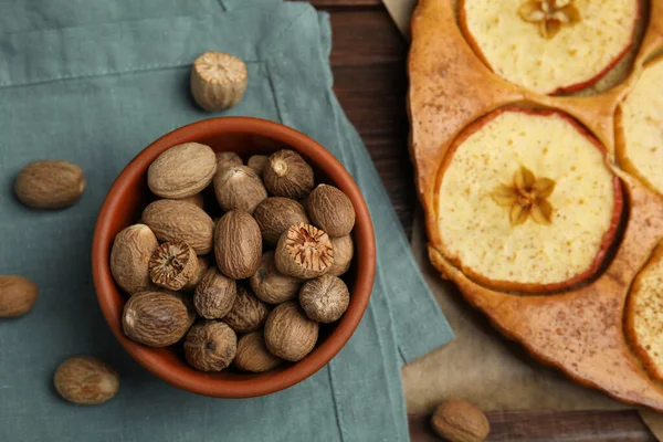 Nutmeg tohumları ve ahşap masada lezzetli elmalı turta.