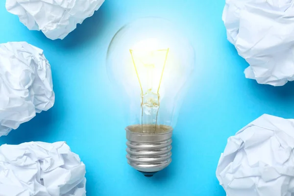 ライトブルーの背景に電球と紙のボールと創造的なフラットレイ組成物 アイデアのコンセプト — ストック写真