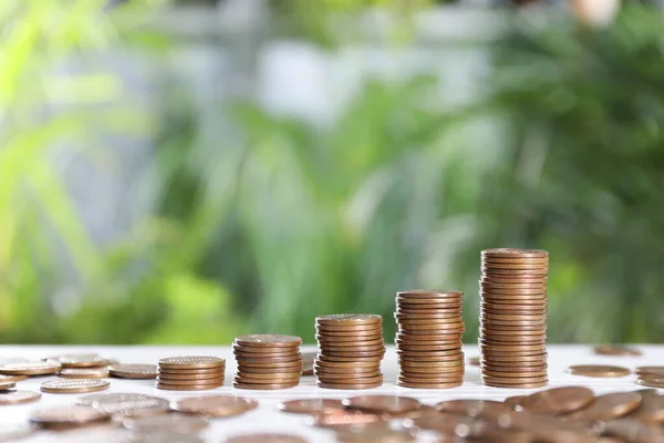 Many Metal Coins White Table Blurred Green Background Space Text — Stock Fotó