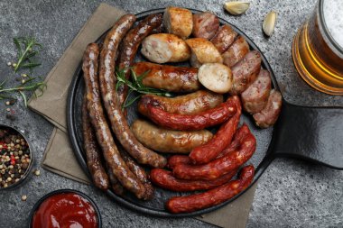 Farklı lezzetli atıştırmalıklar ve biralar koyu gri masada, düz yatıyordu.