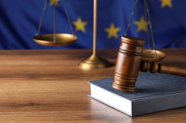 Yargıç tokmağı ve kitabı Avrupa Birliği bayrağına karşı ahşap masa üzerinde. Metin için boşluk