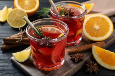 Aromatik punç içeceği ve siyah ahşap masa malzemeleri.