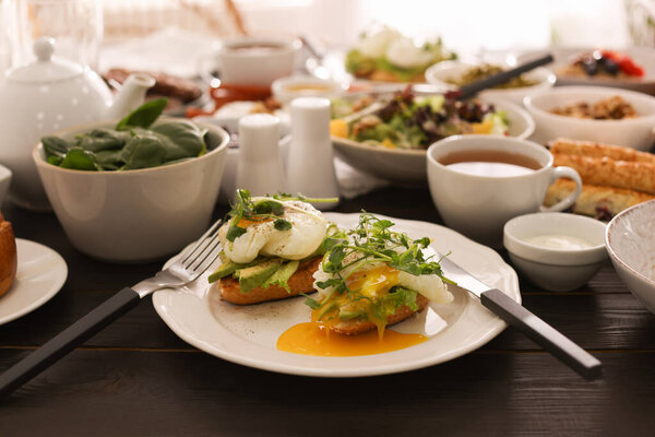 Вкусные бутерброды и разнообразные блюда, подаваемые на обеденном столе