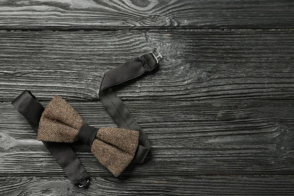 Siyah ahşap arka planda şık bir papyon, üst manzara. Metin için boşluk