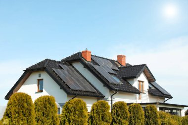 Çatıda güneş panelleri olan bir ev. Alternatif enerji