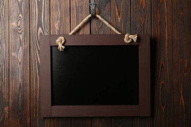 Ahşap duvarda asılı temiz, küçük siyah bir karatahta