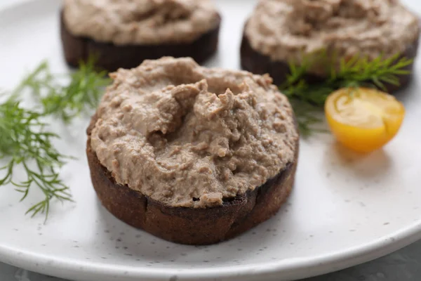 Lezzetli ezmeli ekmek dilimleri, tabakta domates ve dereotu, yakın plan.