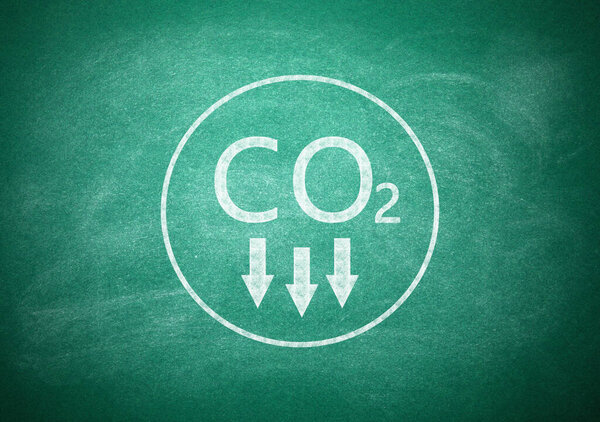 Reduce carbon emissions. Chemical formula CO2 on green chalkboard