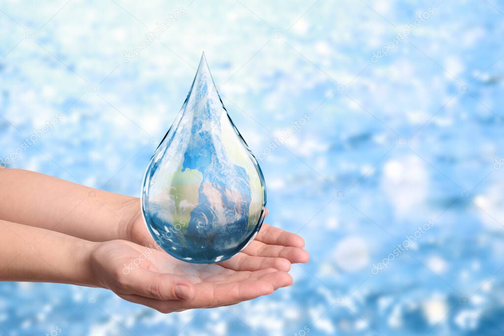 World Water Day. Woman holding icon of drop with Earth image inside on blurred background, closeup
