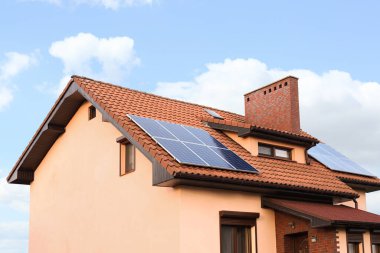 Çatıda güneş panelleri olan bir ev. Alternatif enerji