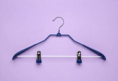 Empty hanger on lilac background, top view