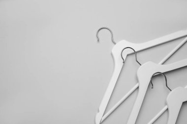 Boş elbise askıları beyaz arka planda, düz yerde. Metin için boşluk