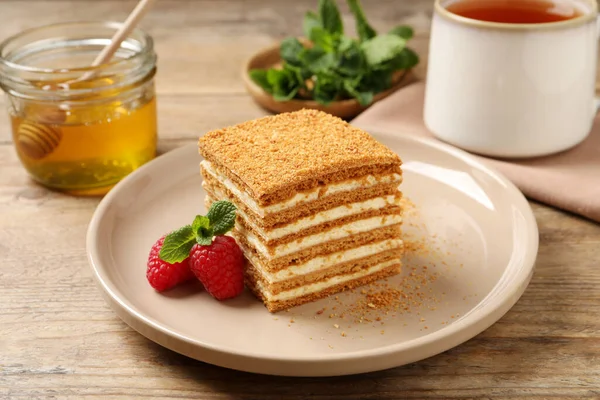 Slice Delicious Layered Honey Cake Served Mint Raspberries Wooden Table — Foto de Stock