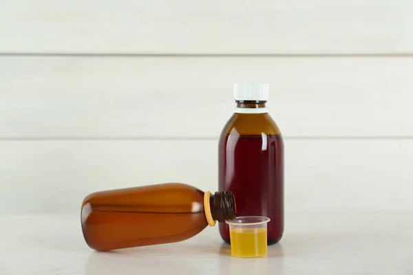 Botol Dan Cangkir Ukur Dengan Sirup Obat Batuk Atas Meja — Stok Foto