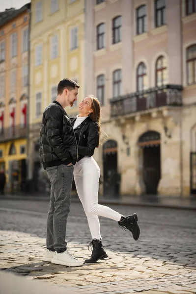 stock image Lovely young couple with cups of coffee walking together on city street. Romantic date