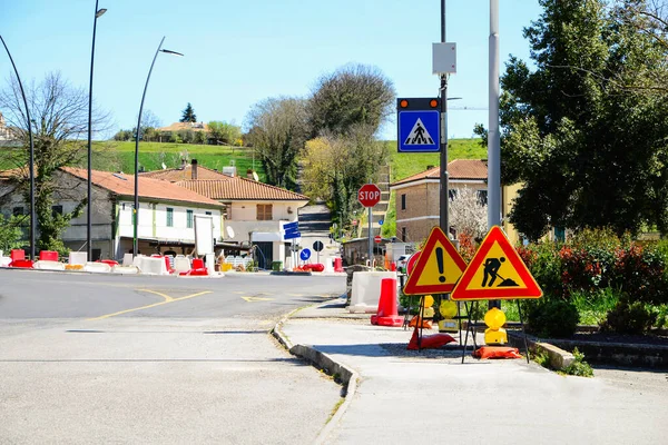 City street with road construction signs and temporary yellow markings on sunny day