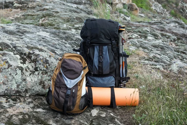 Rugzakken Met Wandelstokken Kampeermat Rotsachtige Heuvel — Stockfoto