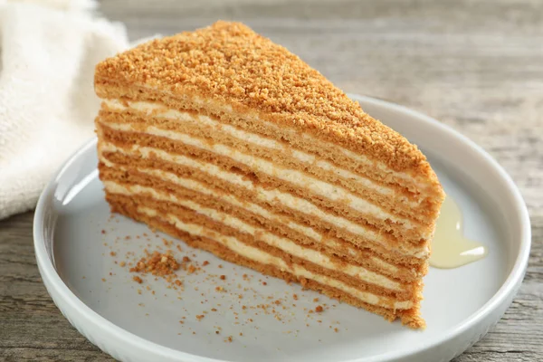 Ahşap masada servis edilen lezzetli katmanlı ballı kek dilimi.