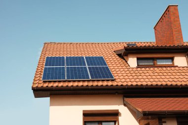 Çatıda güneş panelleri olan bir ev. Alternatif enerji