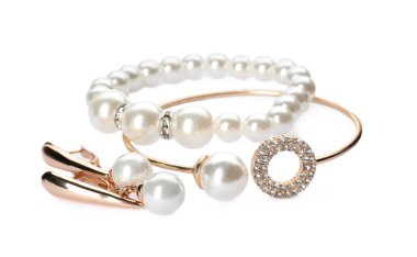 Different elegant jewelry with pearls on white background