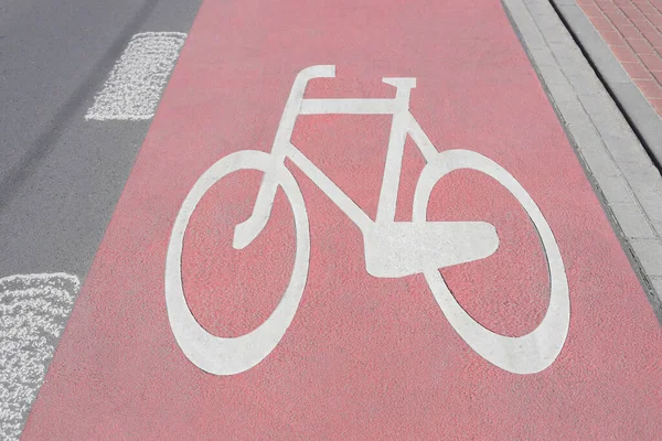 阳光明媚的红色自行车道上有漆成白色的自行车标志 — 图库照片