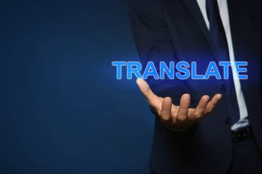 Koyu mavi arka plana karşı TRANSLATE kelimesinin sanal modelini gösteren adam, yakın plan. Metin için boşluk