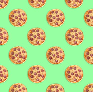 Yeşil arka planda bir sürü lezzetli pepperonili pizza, düzlük. Kusursuz desen tasarımı
