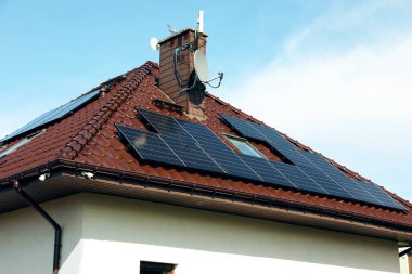 Çatıda güneş panelleri olan bir ev. Alternatif enerji
