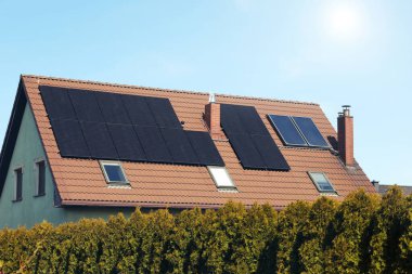 Çatıda güneş panelleri olan bir ev. Alternatif enerji