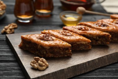 Siyah ahşap masada cevizli enfes tatlı baklava, yakın plan.