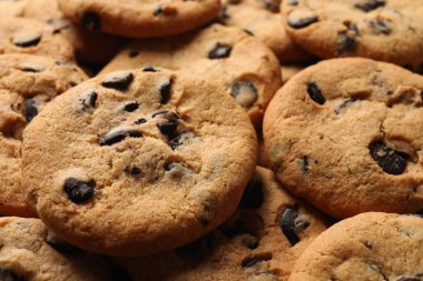 Many delicious chocolate chip cookies as background, closeup
